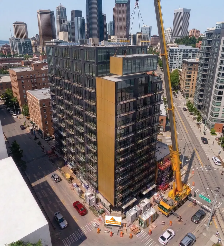 Crane lifting a finished module onto a high-rise volumetric modular building